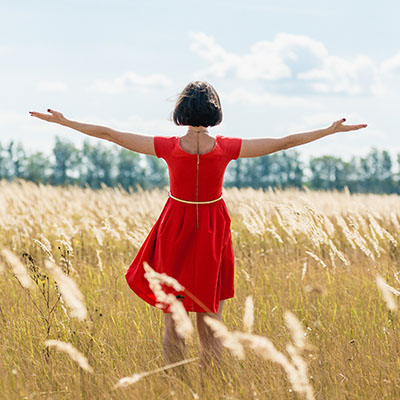 Girl in red dress walking on the field