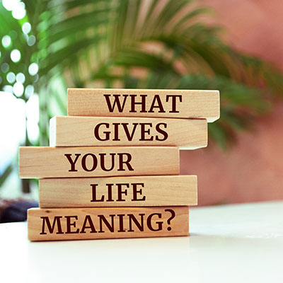 Compass and paper tag written with PURPOSE on wooden background. Wooden blocks with Words on them