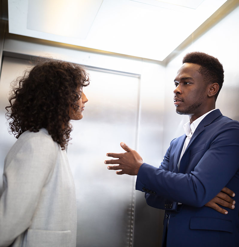 Businesspeople Having Conversation In Elevator Two people in an elevator